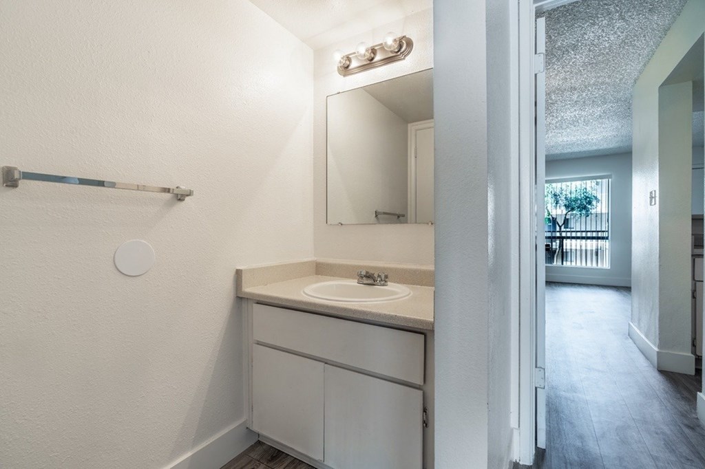 A white bathroom with a sink and mirror.
