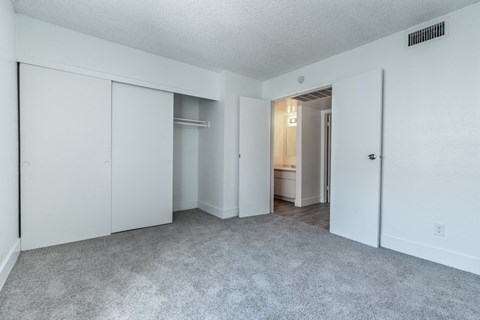 A sparsely furnished room with a carpeted floor and white walls.