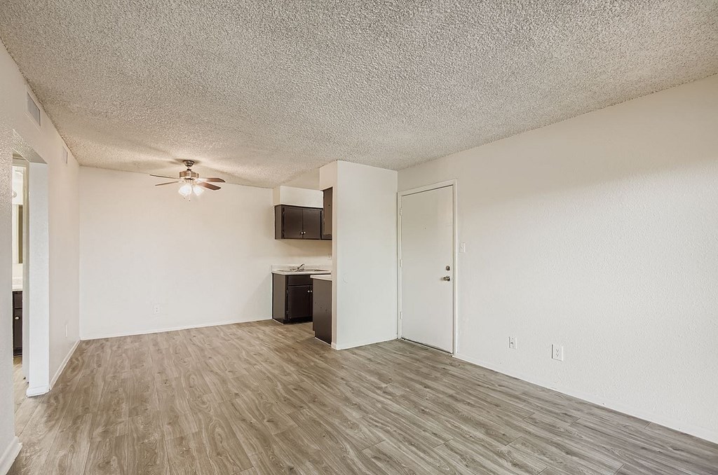 A room with a ceiling fan and a wooden floor.