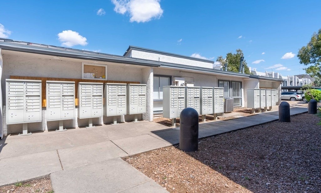 A series of white buildings with brown shutters and a clear blue sky above.