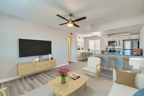 A living room with a wooden coffee table and a flat screen TV mounted on the wall.