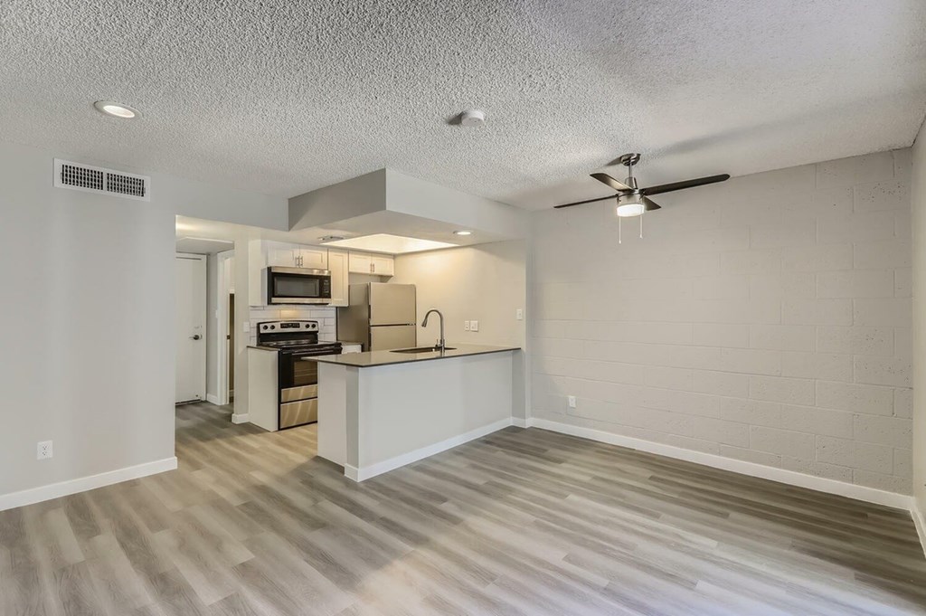 A kitchen area with a counter and a fan.
