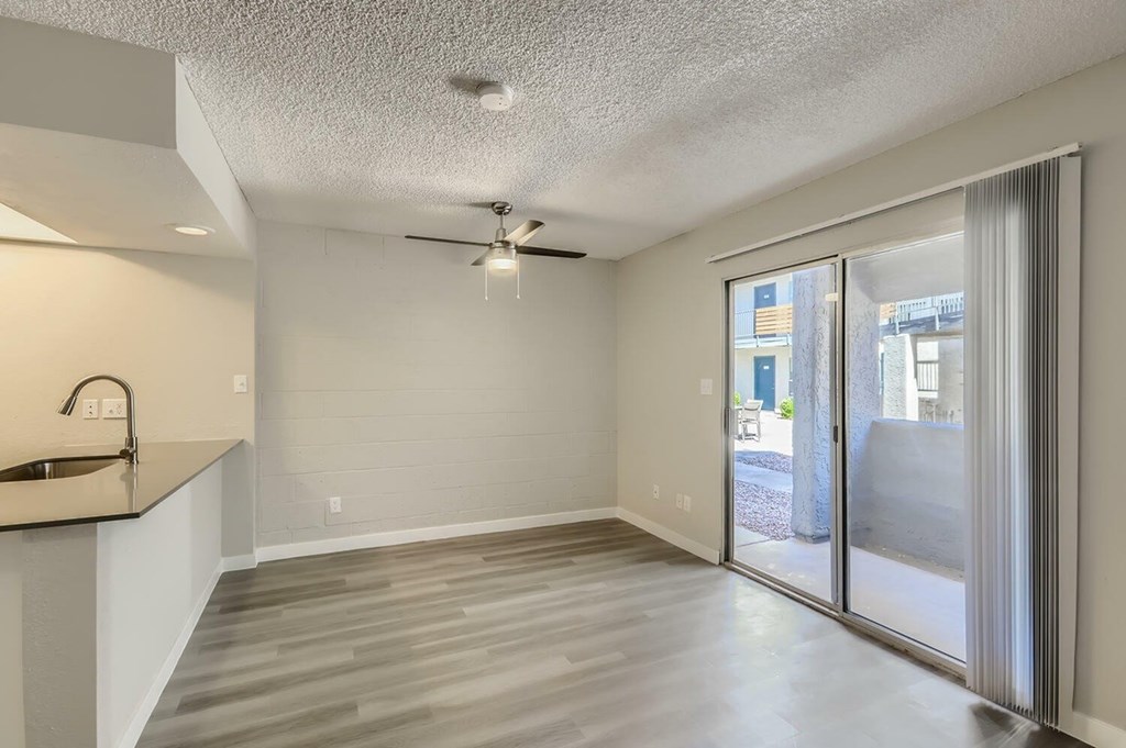 A spacious room with a ceiling fan and sliding glass doors.