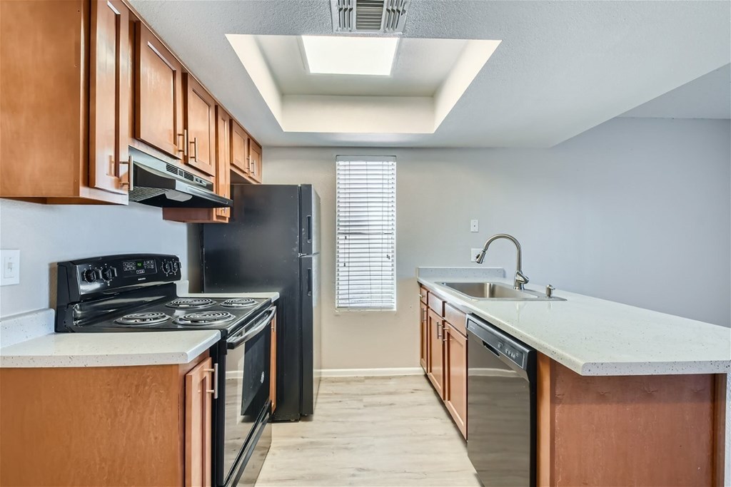 A kitchen with black appliances and wooden cabinets.