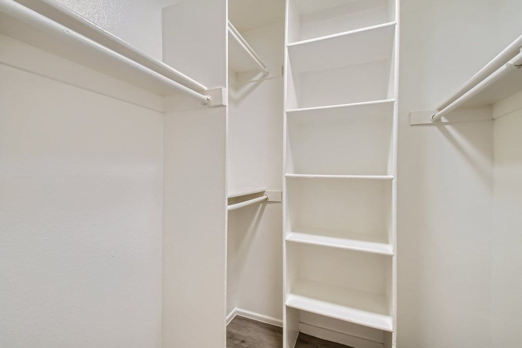 A white shelving unit with multiple shelves is installed in a room.