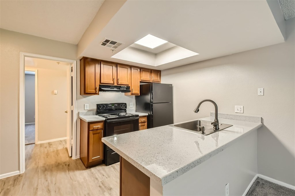 A kitchen with a sink, stove, and refrigerator.