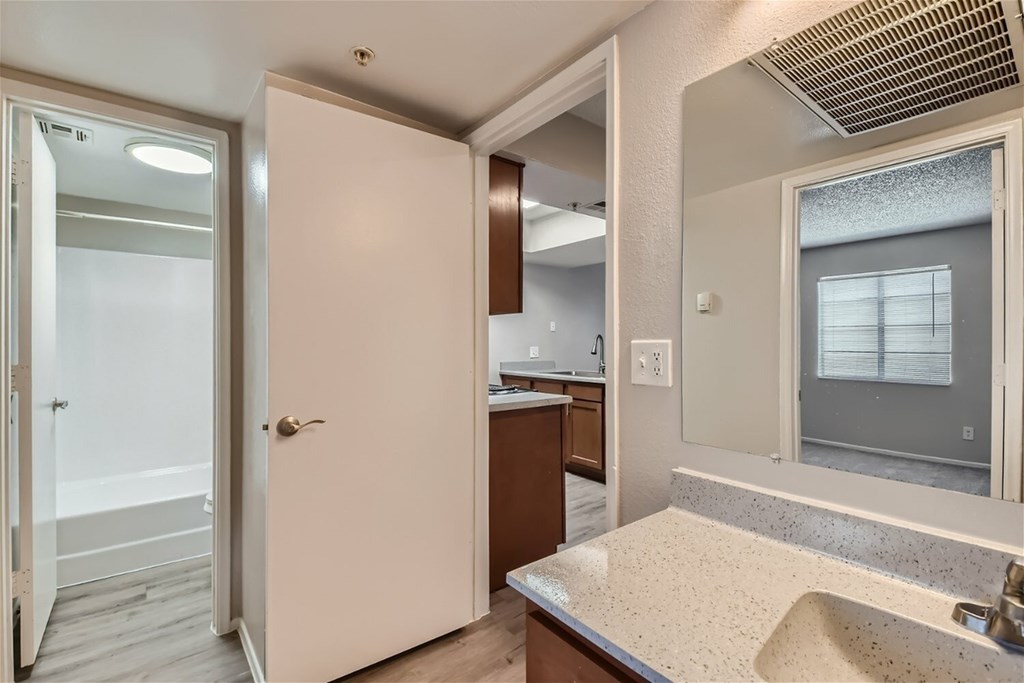 A bathroom with a sink, mirror, and a window.