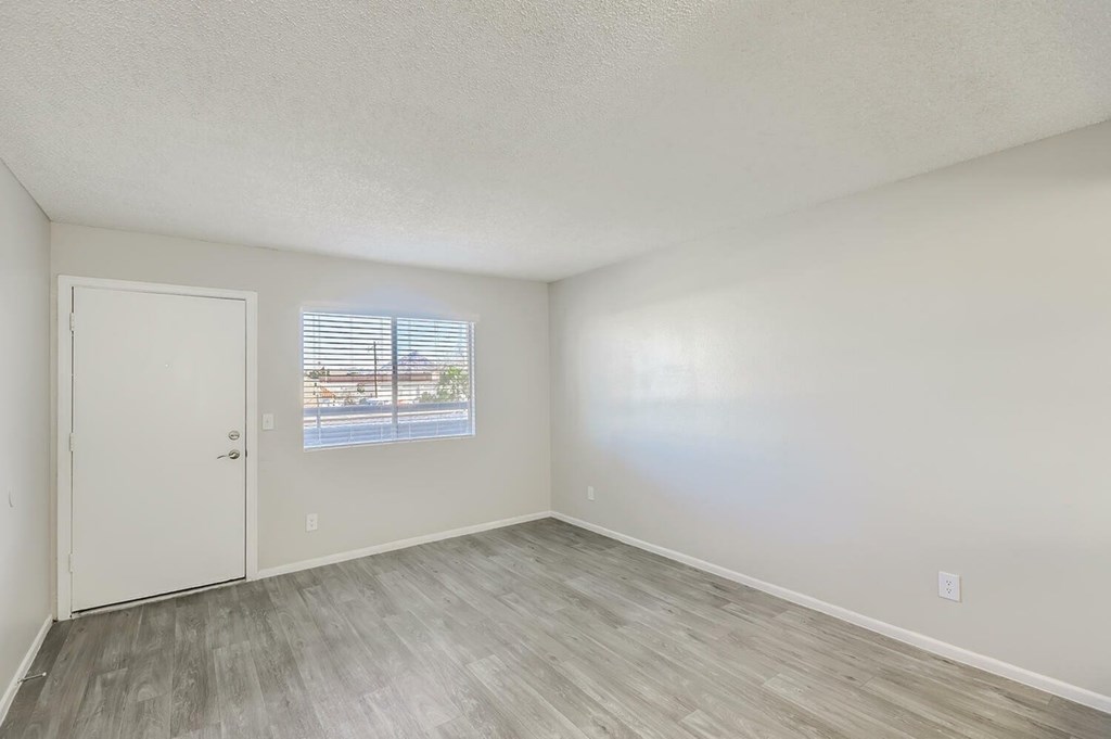 A room with a white door and a window with blinds.
