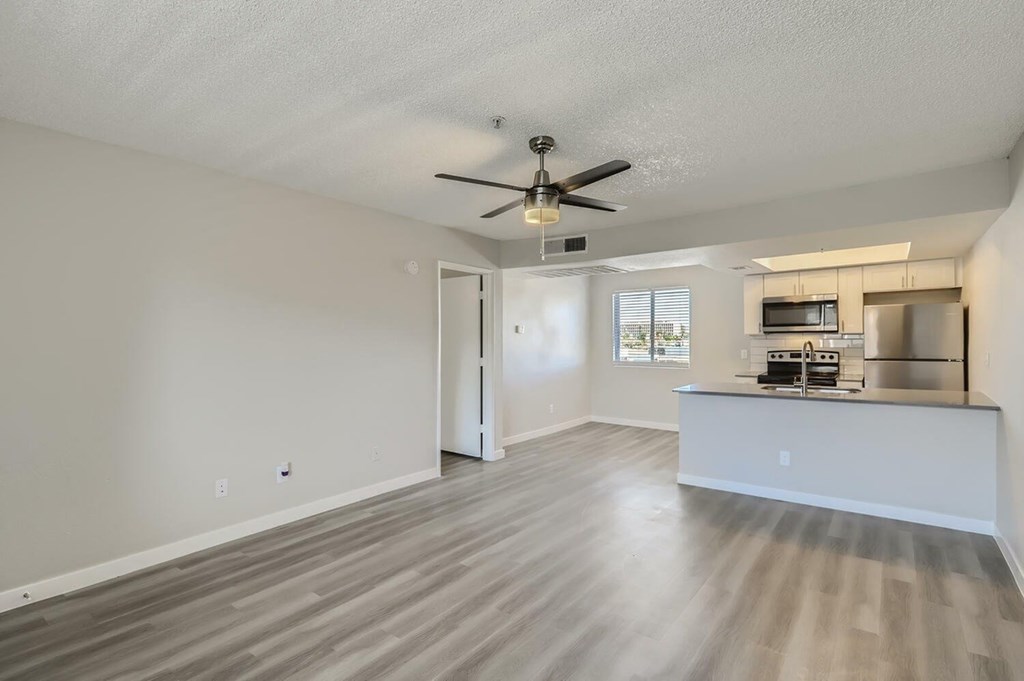 A spacious room with a ceiling fan and light fixture.