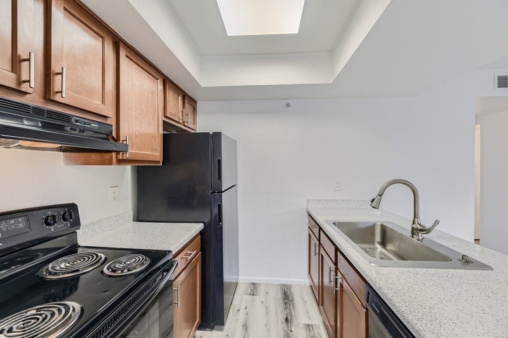 A kitchen with a black stove top oven and a black refrigerator.