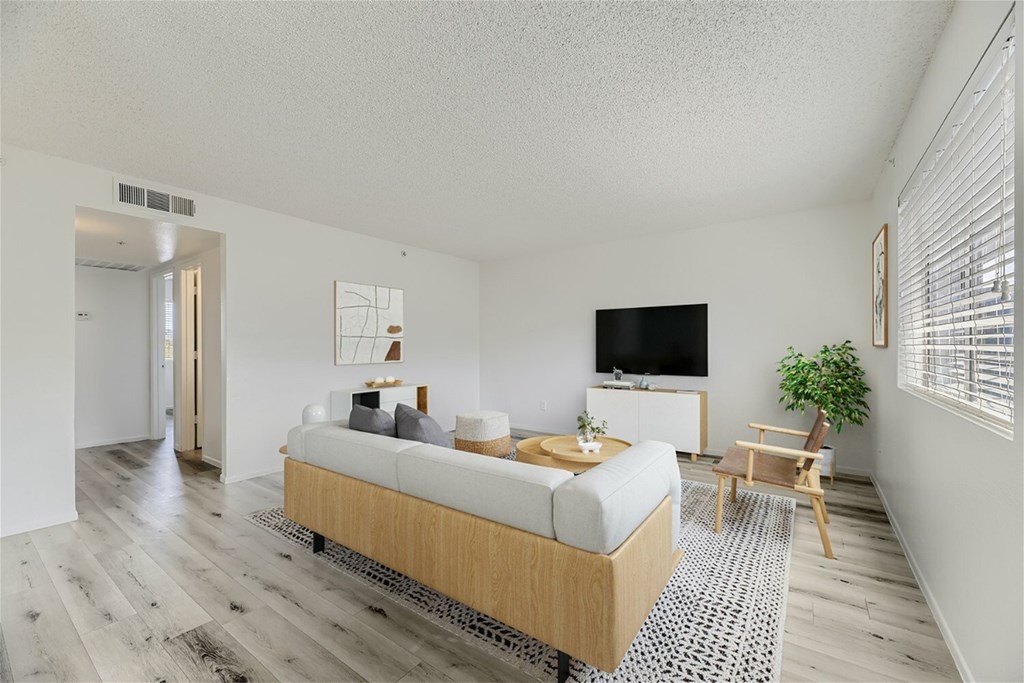 A bedroom with a bed, a chair, and a television.