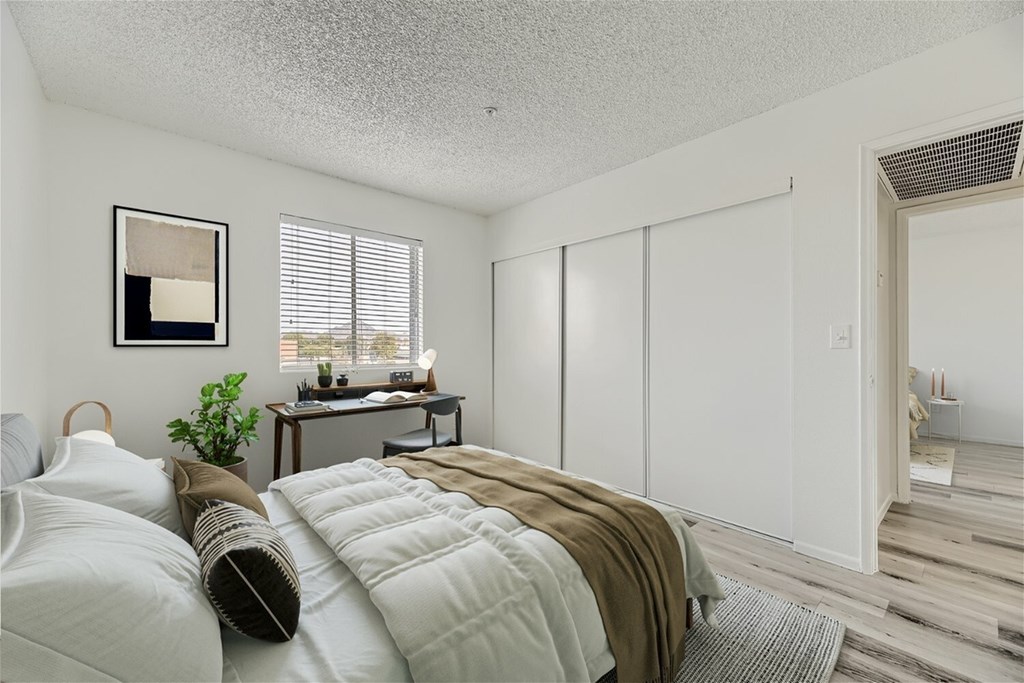 A bedroom with a bed, desk, and chair.