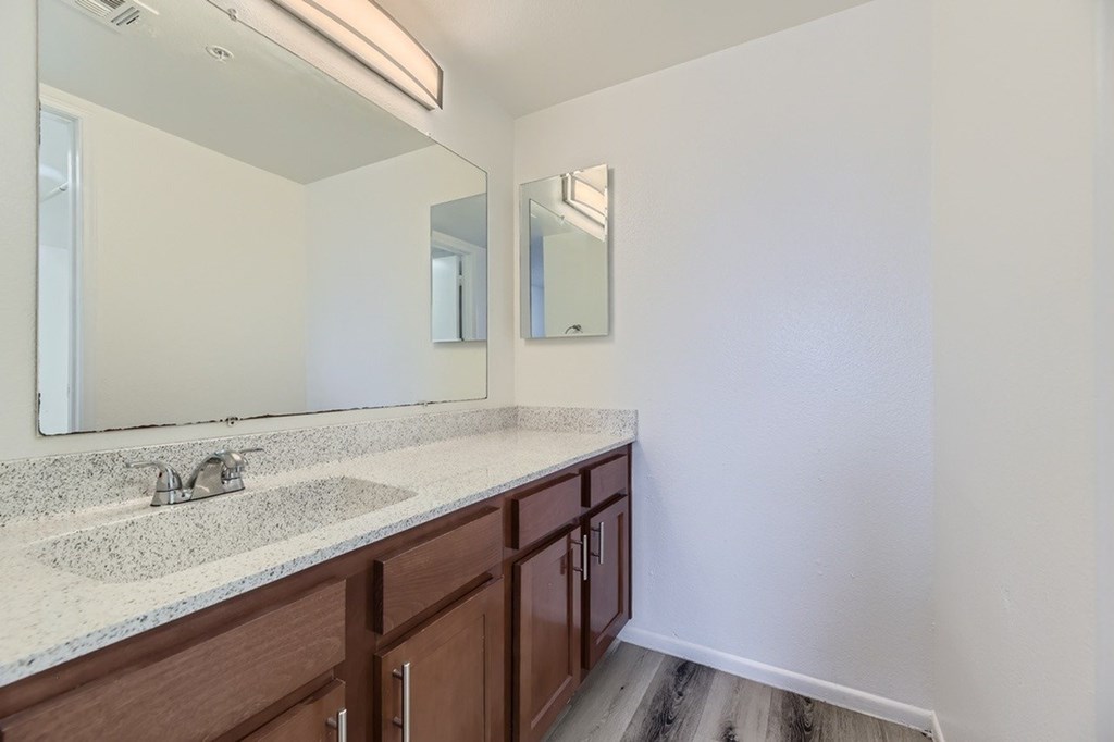 A bathroom with a sink and mirror.
