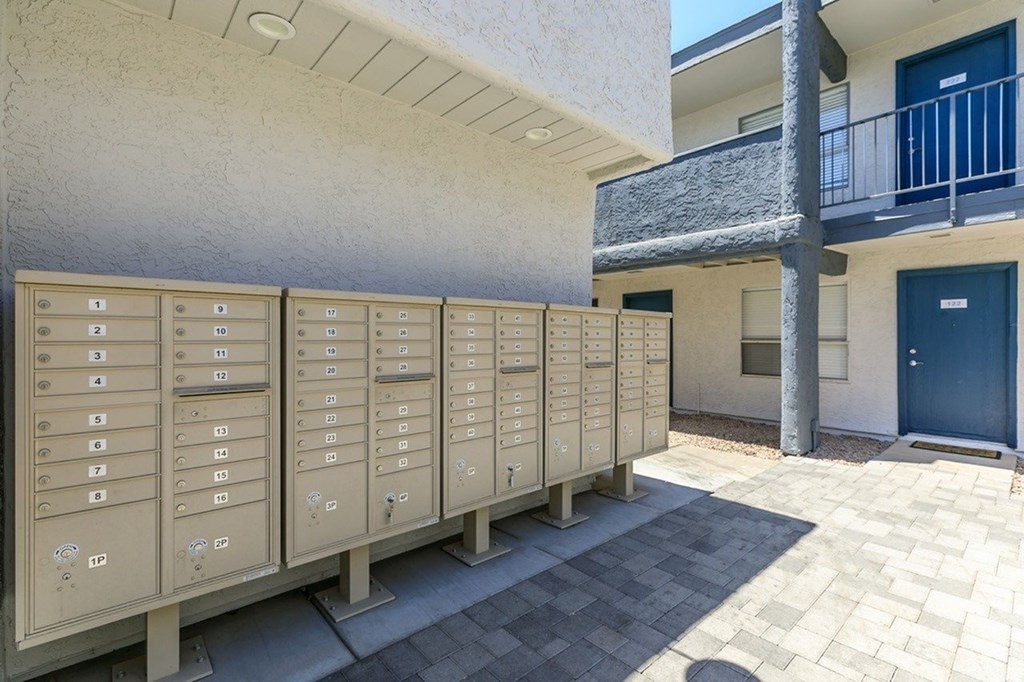 A row of mailboxes are lined up on a sidewalk.