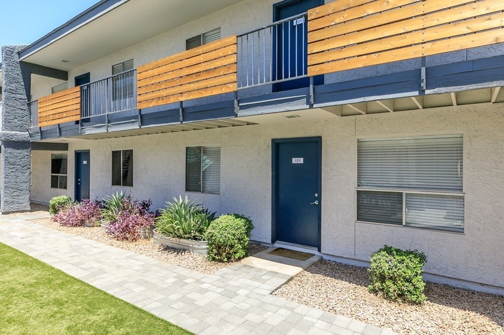 A modern house with a blue door and a balcony.