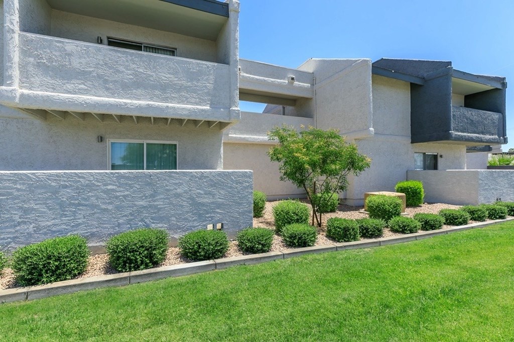A modern building with a green lawn in front.