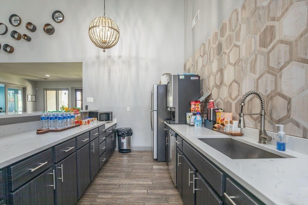 A kitchen with a black fridge and a black and white tiled wall.