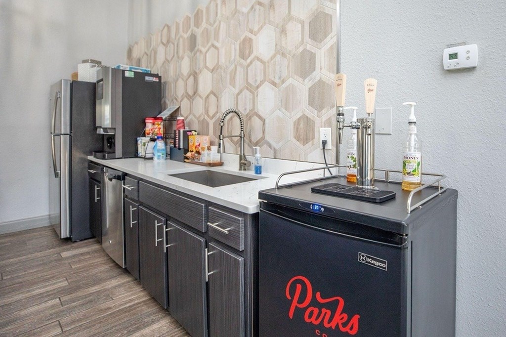 A kitchen with a black fridge and a sink.