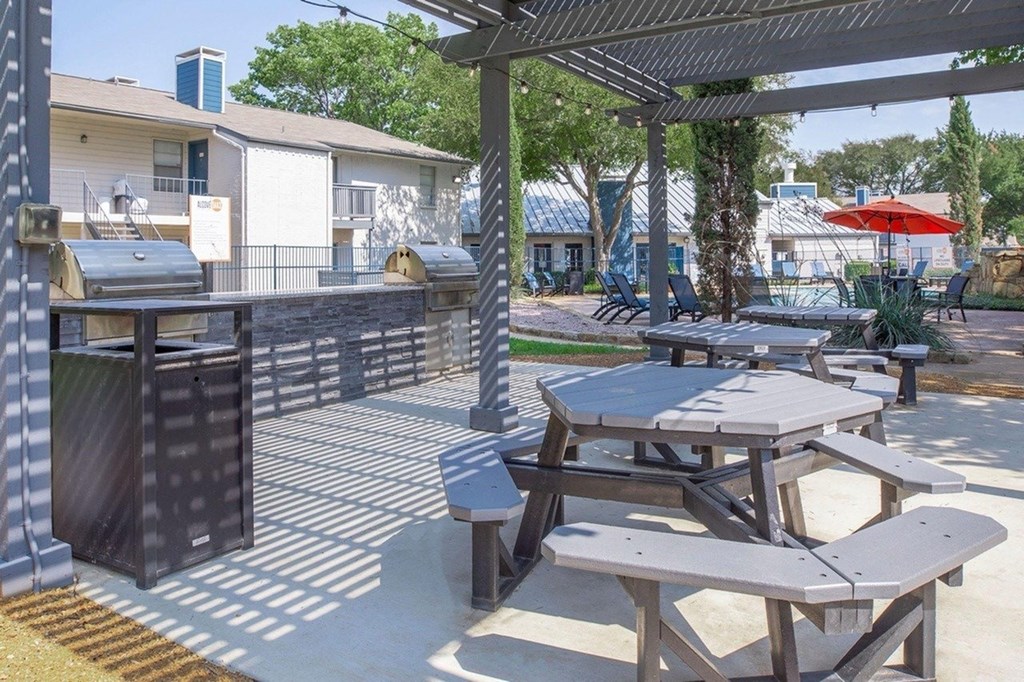 A patio with tables and chairs under a canopy.