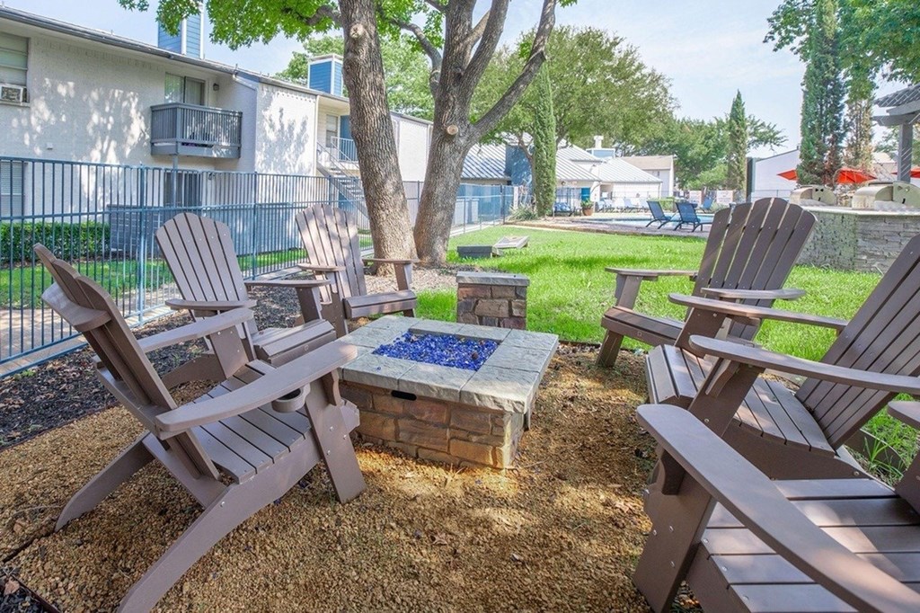 A small fire pit surrounded by chairs in a backyard.