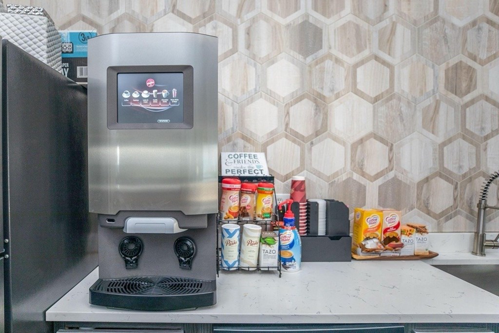 A coffee machine is on a counter with a variety of food items.