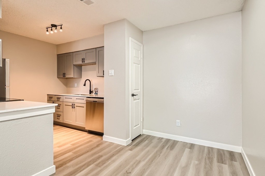 A kitchen with white cabinets and a white countertop.