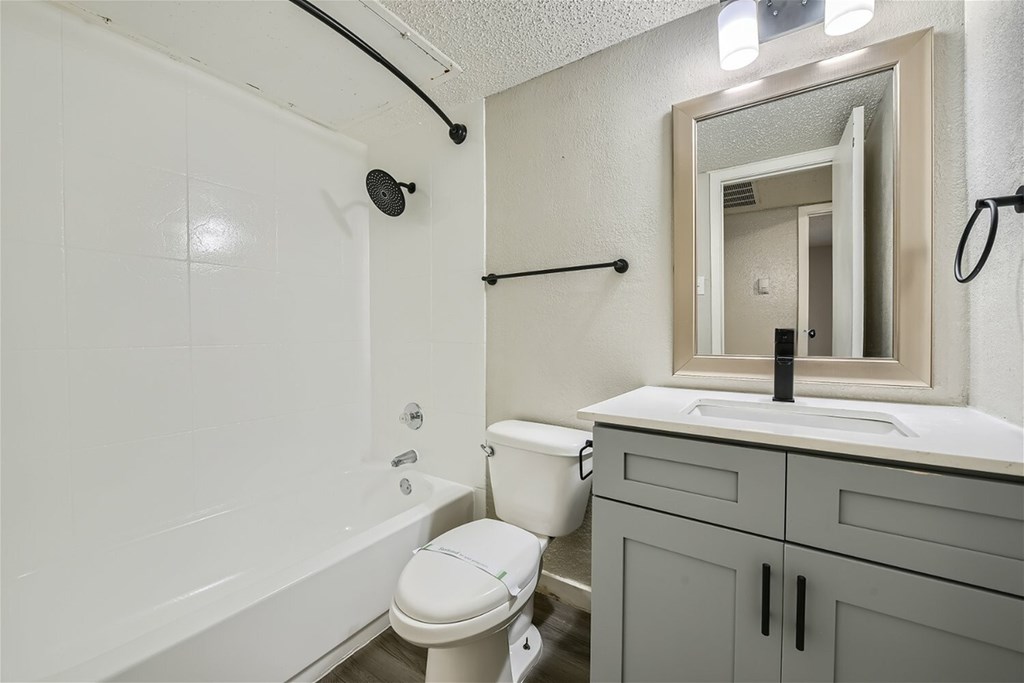 A white bathroom with a toilet, sink, and bathtub.