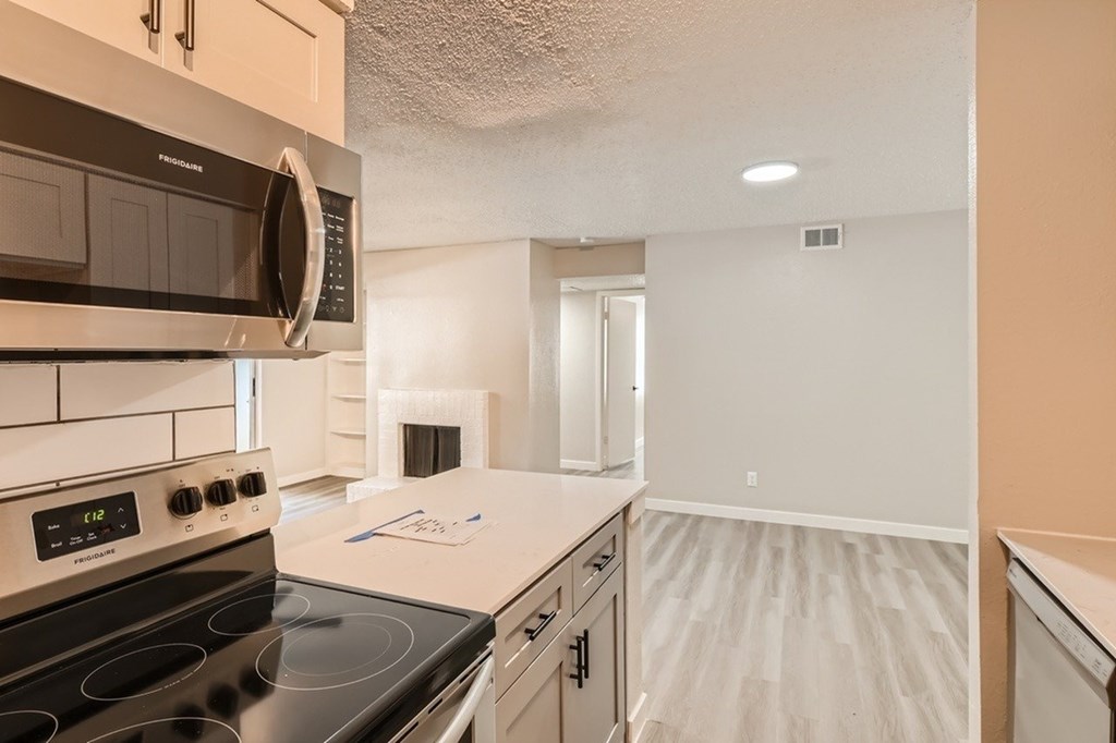 A kitchen with a stove, microwave, and oven.