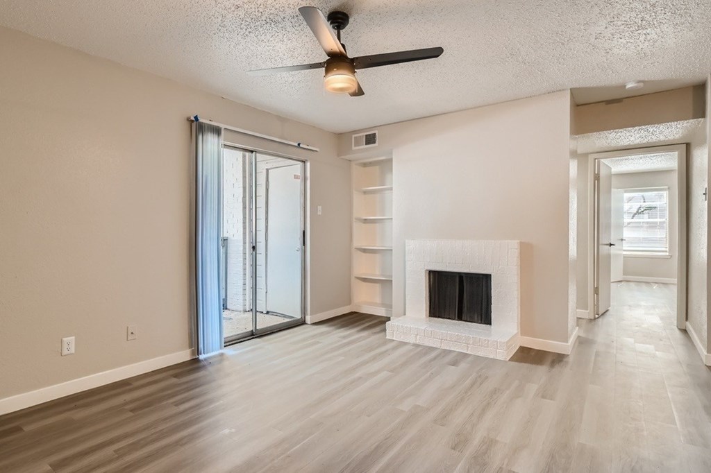 A spacious living room with a fireplace and sliding glass doors.