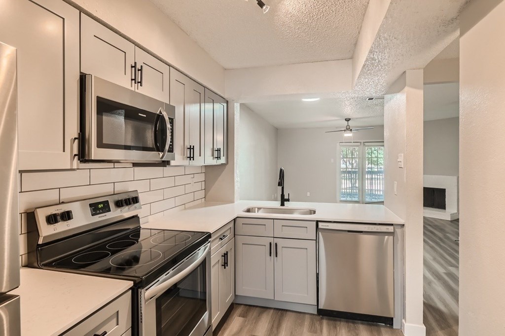 A kitchen with white appliances and cabinets.