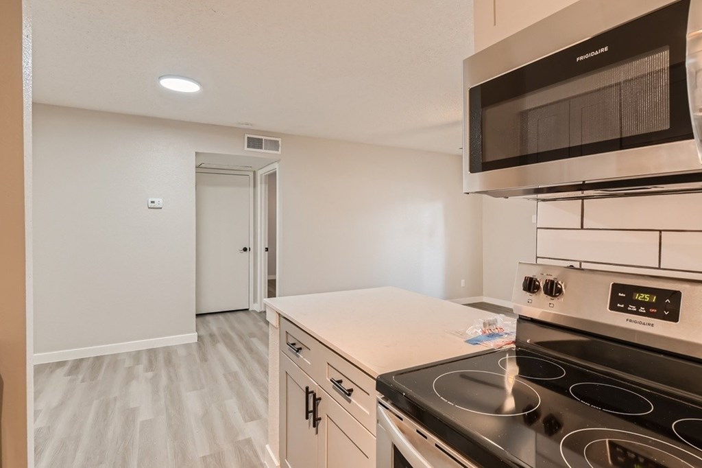 A kitchen with a stove, oven, and microwave.