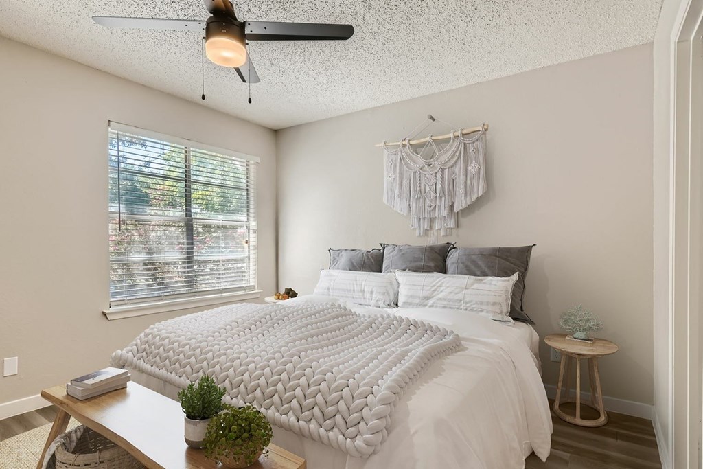A bedroom with a large bed and a ceiling fan.