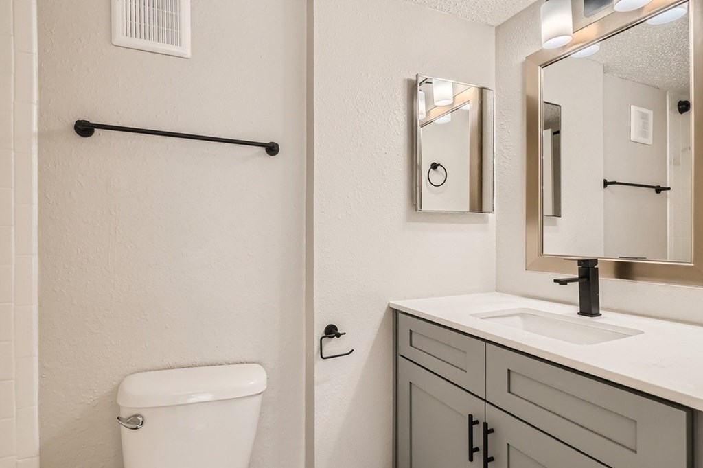 A white toilet is next to a sink in a bathroom.