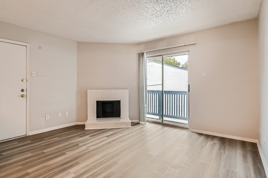 A room with a fireplace and sliding glass doors.