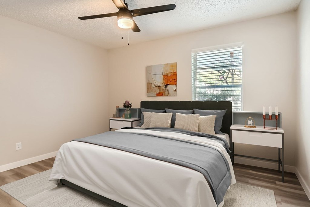 A bedroom with a large bed and a ceiling fan.