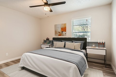 A bedroom with a large bed and a ceiling fan.