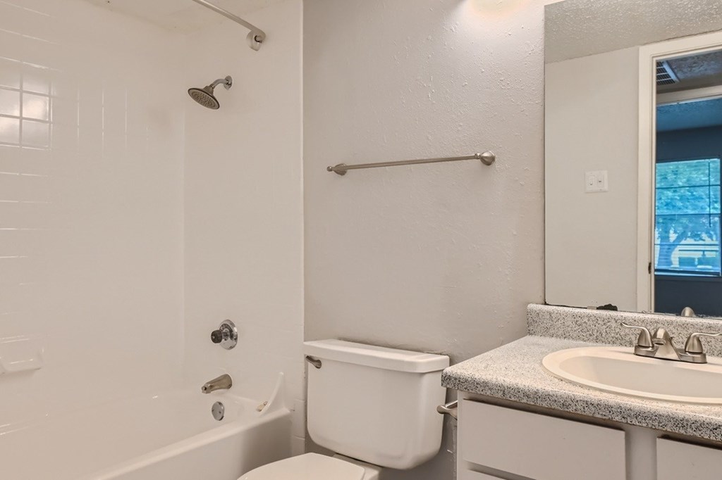 A white bathroom with a toilet, sink, and bathtub.