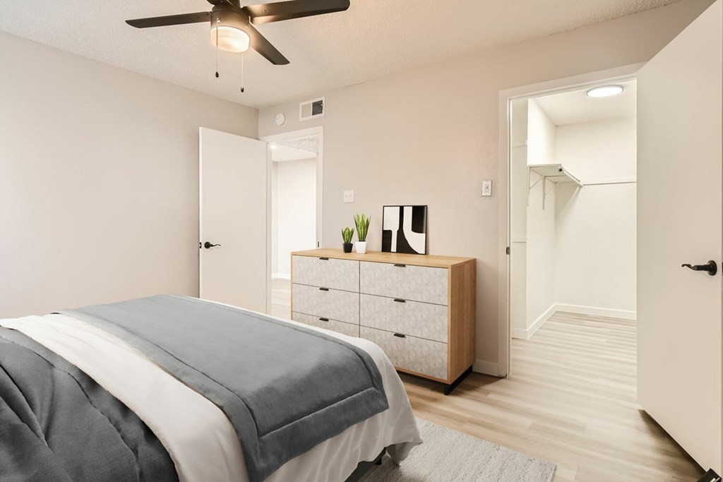 A bedroom with a bed, dresser, and mirror.
