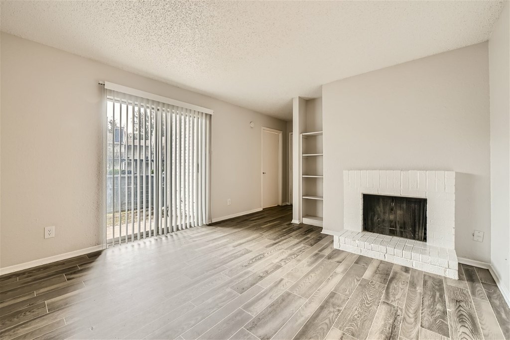 A living room with a fireplace and a sliding glass door.