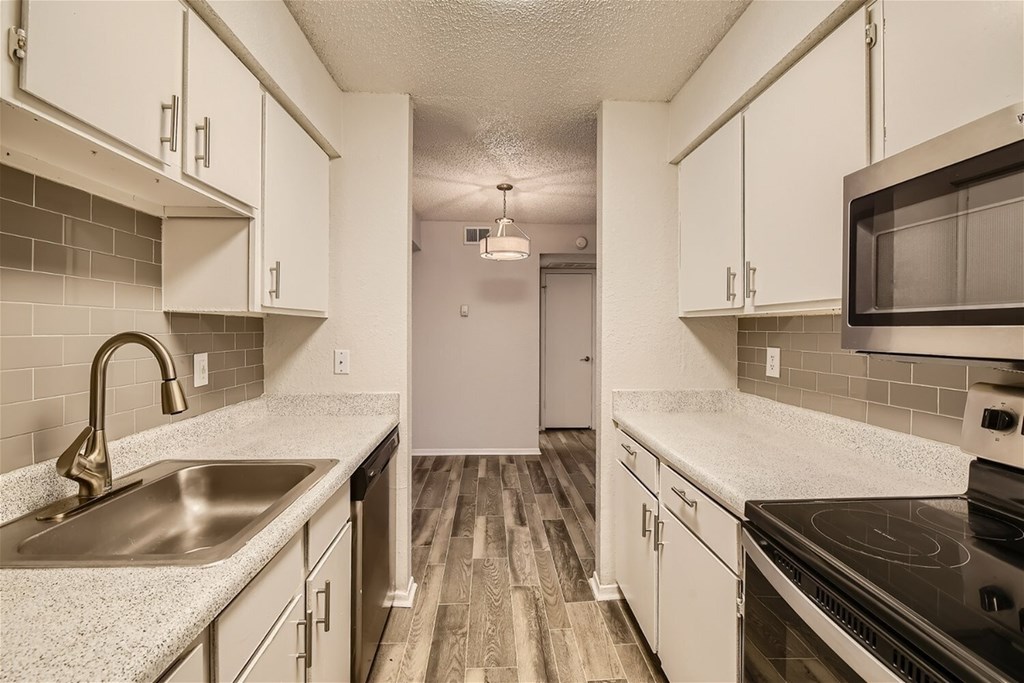 A kitchen with white cabinets and a black stove top oven.