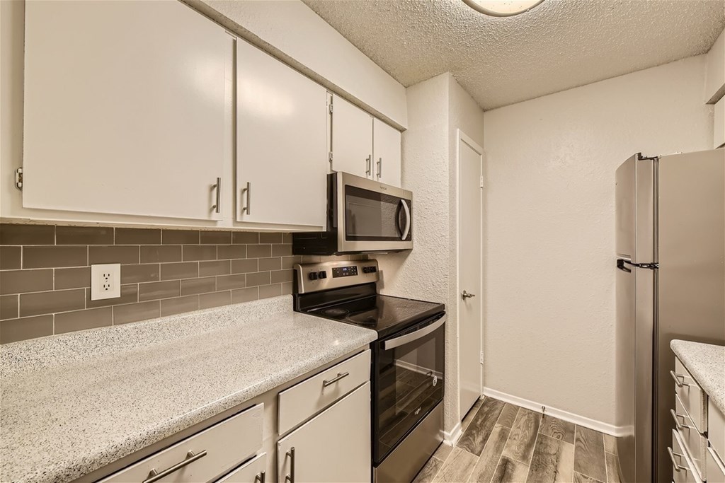 A kitchen with white cabinets and a black stove top oven.