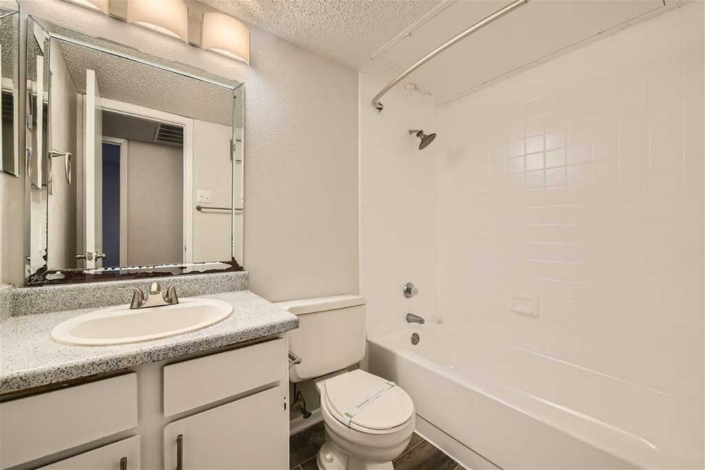 A white bathroom with a sink, toilet, and bathtub.
