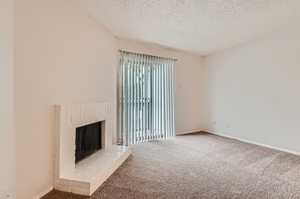 A room with a fireplace and carpeted floor.