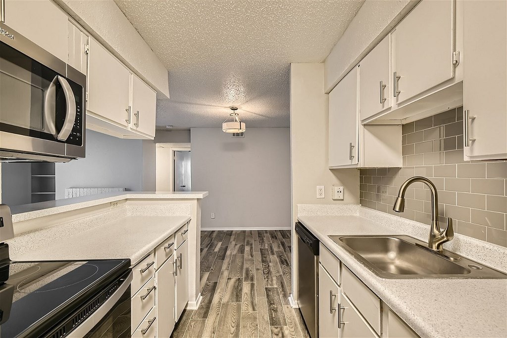 A kitchen with white cabinets and a granite countertop.