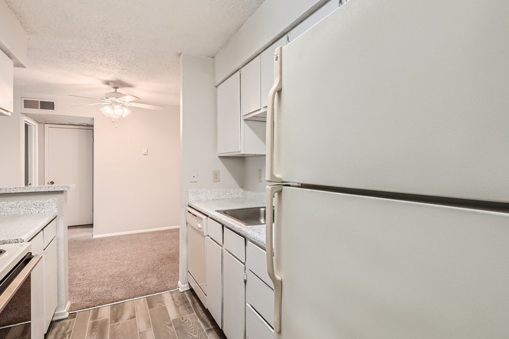A kitchen with white appliances and cabinets.