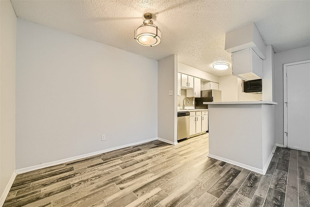 A room with a carpeted floor and a window with blinds.