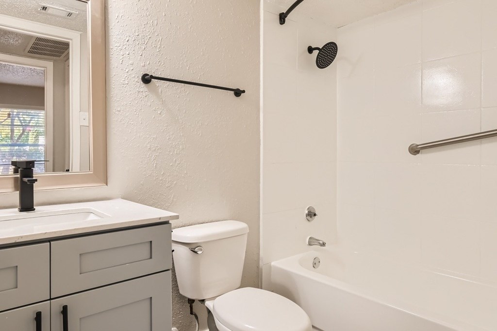 A white bathroom with a toilet, sink, and bathtub.