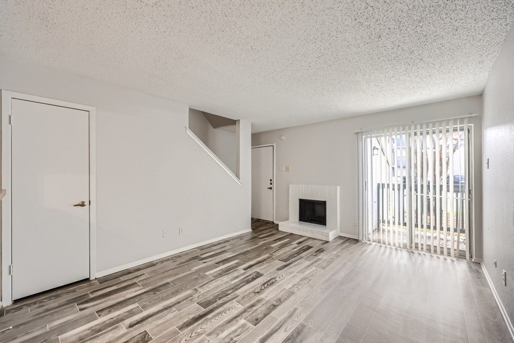 A room with a fireplace and a window with blinds.