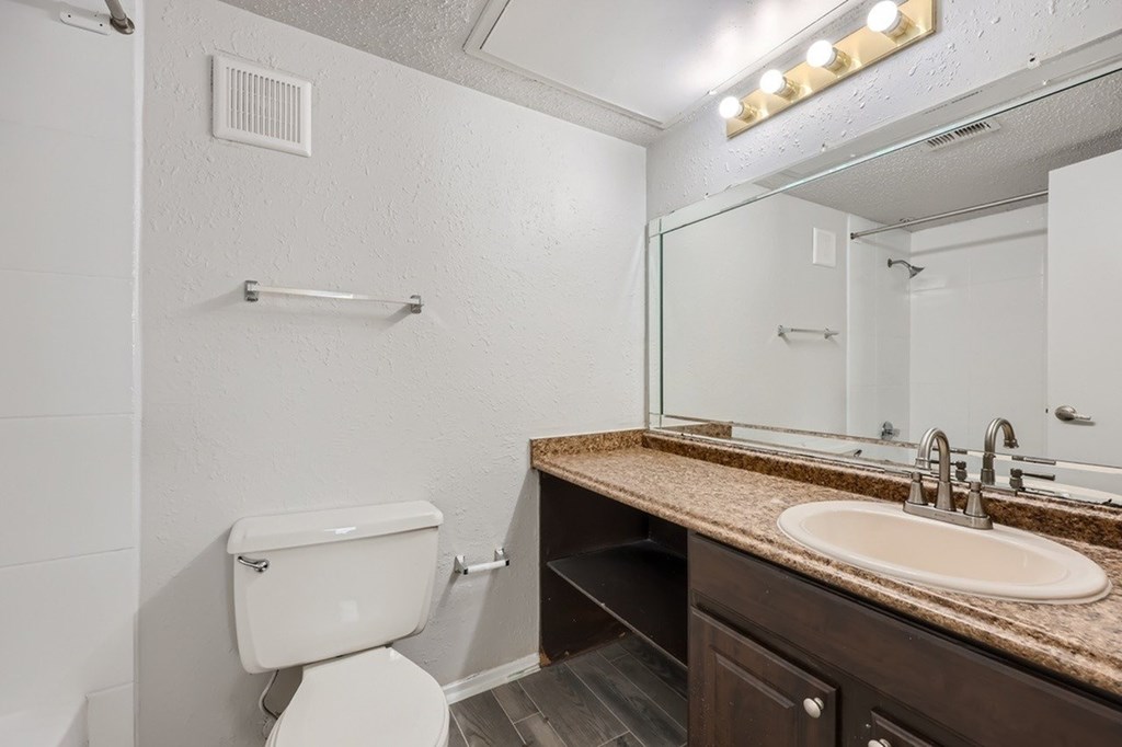 A white toilet sits next to a sink in a bathroom.