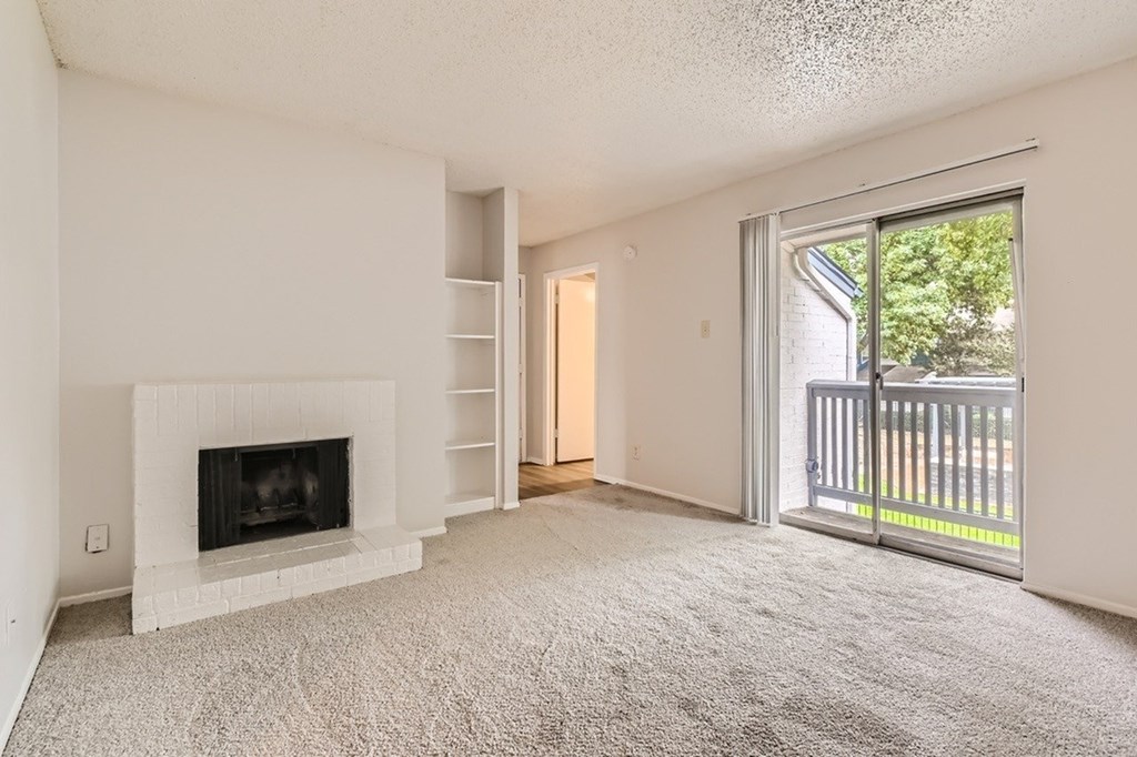 A living room with a fireplace and a carpeted floor.